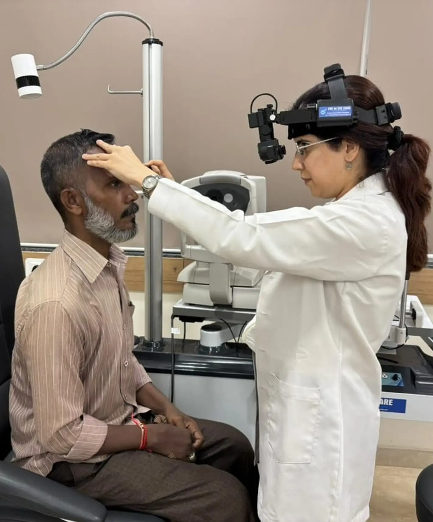 Dr. Sahiba Bedi performing an eye examination on a patient with advanced optometry equipment in the clinic
